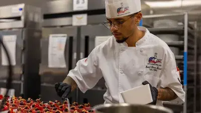 Members of Culinary Team USA prepare dishes for a fundraising dinner at Wake Tech that will help pay for expenses during the team's trip to Germany for the 2028 Culinary Olympics.