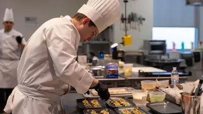 Members of Culinary Team USA prepare dishes for a fundraising dinner at Wake Tech that will help pay for expenses during the team's trip to Germany for the 2028 Culinary Olympics.