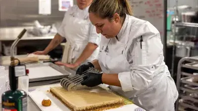 Members of Culinary Team USA prepare dishes for a fundraising dinner at Wake Tech that will help pay for expenses during the team's trip to Germany for the 2028 Culinary Olympics.