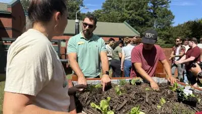 Wake Tech students plant seedlings in the vegetable garden on Southern Wake Campus.