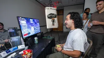 A man plays a video game created by Wake Tech students at the Simulation and Game Development annual Student Showcase.
