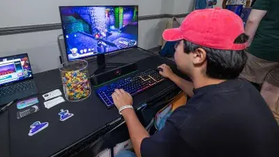 A man plays a video game created by Wake Tech students at the Simulation and Game Development annual Student Showcase.