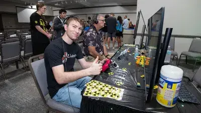A man plays a video game created by Wake Tech students at the Simulation and Game Development annual Student Showcase.