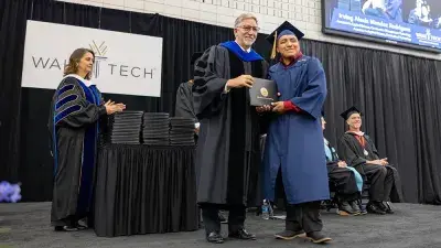 Wake Tech student process into the auditorium for the Fall 2025 commencement ceremony.
