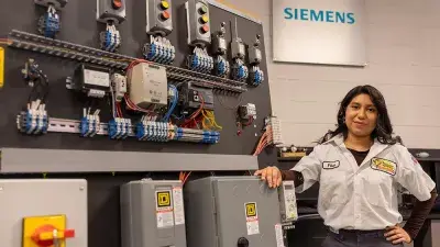 image of Pilar Andrande-Rosalino, Wake Tech graduate, standing in front of circuitry