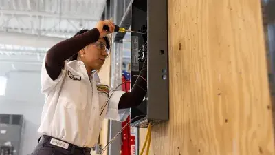image of Pilar Andrande-Rosalino, Wake Tech graduate, standing in front of circuitry