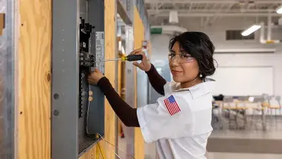 image of Pilar Andrande-Rosalino, Wake Tech graduate, standing in front of circuitry