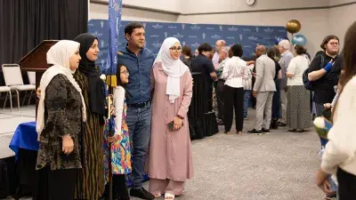 A female Wake Tech student smiles as she processes in at the start of the Phi Theta Kappa honor society induction ceremony.