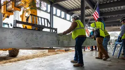 Jim Perry signs the final steel beam for the future Perry Family Simulation Hospital.