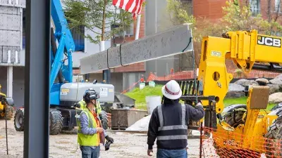 Jim Perry signs the final steel beam for the future Perry Family Simulation Hospital.
