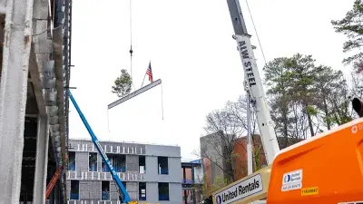 Jim Perry signs the final steel beam for the future Perry Family Simulation Hospital.