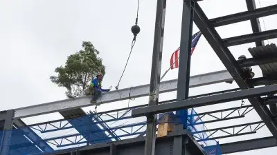 Jim Perry signs the final steel beam for the future Perry Family Simulation Hospital.