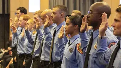 New firefighters take oath of service at recent Fire Academy graduation.