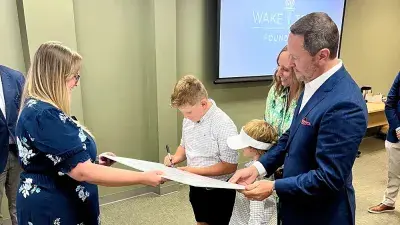 Will Smith's children sign an oversized check after announcing an endowed scholarship the Smith family created at Wake Tech.