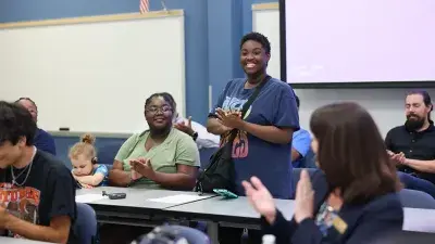 A new Wake Tech student celebrates the completion of the Eagle Start Summer Bridge Program with college staff.