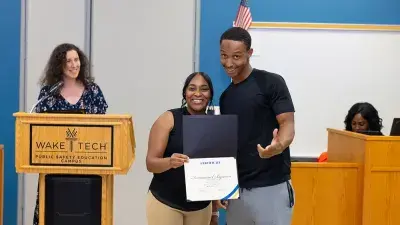 A new Wake Tech student celebrates the completion of the Eagle Start Summer Bridge Program with college staff.
