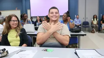 A new Wake Tech student celebrates the completion of the Eagle Start Summer Bridge Program with college staff.