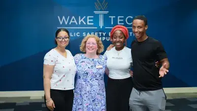 A new Wake Tech student celebrates the completion of the Eagle Start Summer Bridge Program with college staff.