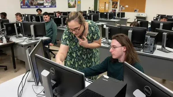 Associate Professor Amber Johnson works with a student in a Simulation & Game Development class.