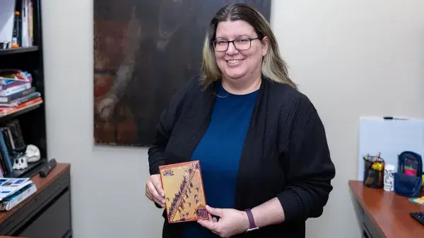 Fine Arts Assistant Professor Rebecca Smith holds a copy of "Ladder of Divine Ascent," a 12-century Byzantine icon.