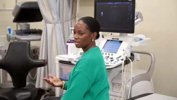 Assistant Professor Shantel McNeill sits next to an ultrasound scanner during a class.