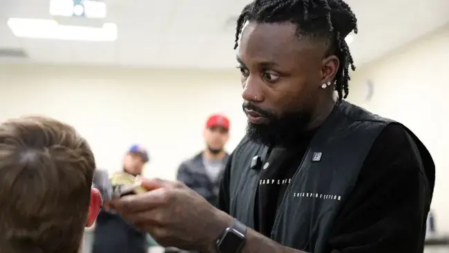 Wake Tech graduate Aaron Norris shows how to do a fade haircut during a School of Barbering continuing education class.