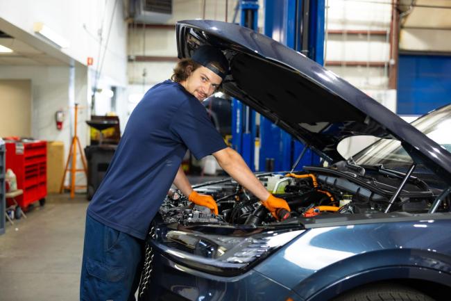 Wake Tech graduate Alexander Kirschenbauer works on an automobile engine.