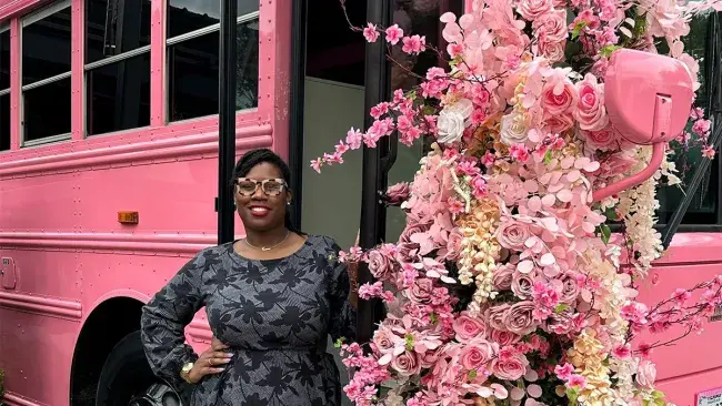 Wake Tech graduate Kierra Bonner stands next to her pink party bus.