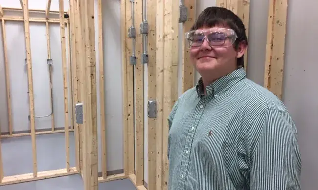 Image of person standing in front of wall framing